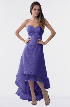 a woman in a strapless purple dress poses for the camera with her hands on her hips