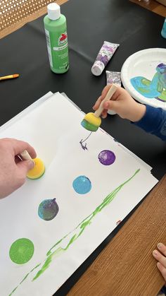 two children are doing arts and crafts at a table