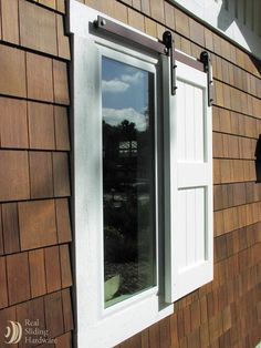 the side of a house with a window and shutters