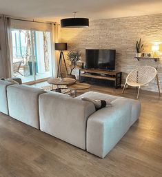 a living room filled with furniture and a flat screen tv sitting on top of a wooden floor