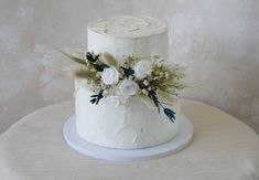 a white wedding cake with flowers on top