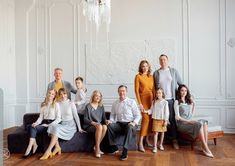 a group of people sitting on top of a couch in front of a chandelier