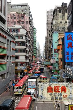 a city street filled with lots of traffic and tall buildings on both sides of it