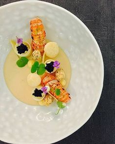 a white plate topped with food and garnishes on top of a table