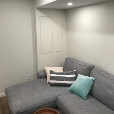 a grey couch with blue and white pillows