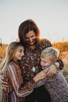 three children hugging their mother in the desert