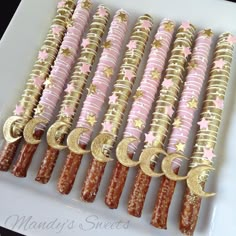 pink and gold decorated pretzels on a white platter with stars, moon and crescents