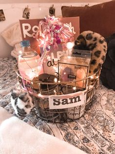 a basket filled with items sitting on top of a bed next to a stuffed animal