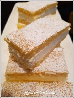 three pieces of cake sitting on top of a white plate covered in powdered sugar