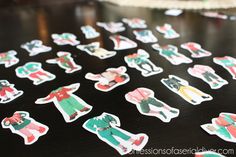 a table topped with lots of christmas stickers on top of it's black surface