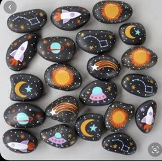 painted rocks with rockets, planets and stars are arranged in the shape of a circle