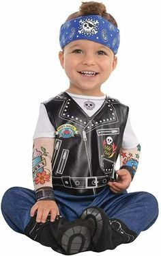 a young boy sitting on the ground wearing a leather vest and bandanna with tattoos