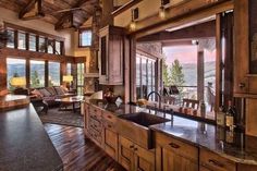 a kitchen with wooden cabinets and an island in front of a window overlooking the mountains