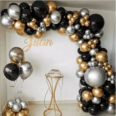 a bunch of balloons that are in the shape of a wreath on a table with a vase