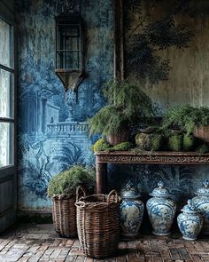 an old room with blue and white vases on the floor, plants in wicker baskets next to them