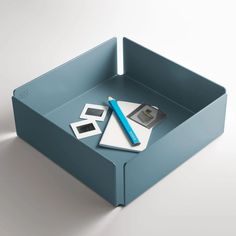 a blue box with two photos and a pen on it, sitting in front of a white background