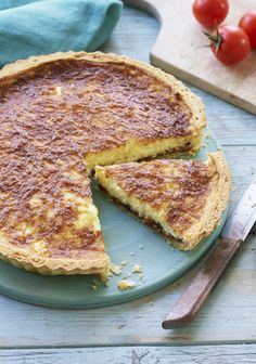 a cheesecake on a blue plate with a knife and fork next to it, ready to be eaten