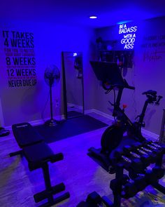 an exercise room is lit up with purple lighting