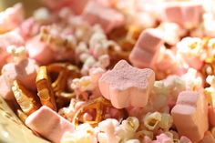 pink and white marshmallows in a bowl with pretzels on the side