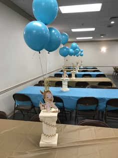 blue balloons are floating in the air over tables