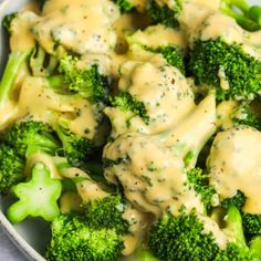 broccoli covered in gravy sitting on top of a white plate