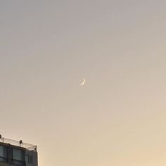 the moon is visible over an apartment building