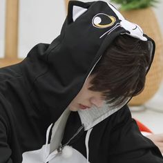 a young man wearing a black and white cat hoodie