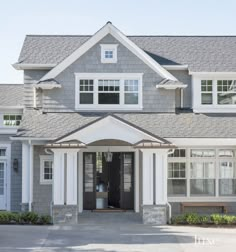 a large gray and white house with lots of windows