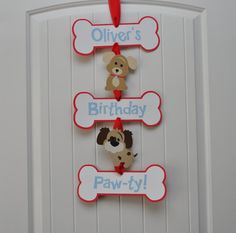 a door hanger with three dogs on it that says,'ollier's birthday paw -ty '