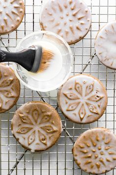 cookies cooling on a wire rack with icing being drizzled onto them