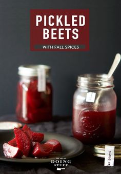 pickled beets with fall spices on a plate next to jars and spoons