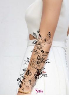 a woman's arm with flowers and butterflies on it