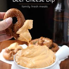 a hand holding a pretzel over a bowl of peanut butter with the words, beer cheese dip family fresh meals