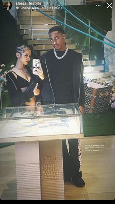 a man and woman standing next to each other in front of a glass display case