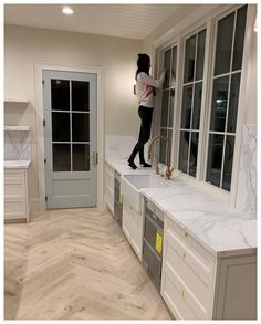 a woman standing on top of a kitchen counter