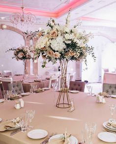 the centerpieces on this table are filled with white and pink flowers