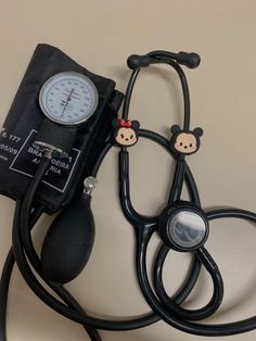 a stethoscope with two teddy bears on it next to a blood pressure meter