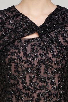 the back of a black dress with sequins on it