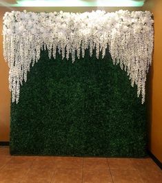 the wall is covered with artificial flowers and greenery