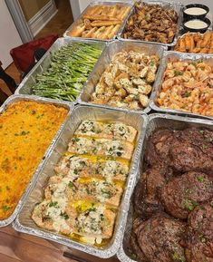 many trays of food are arranged on a table