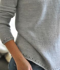 a close up of a person wearing a sweater and holding their hands in their pockets