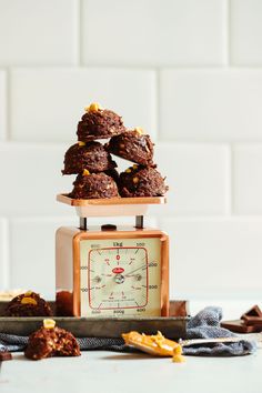 chocolate cookies stacked on top of an old fashioned kitchen scale