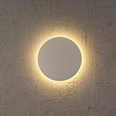 a white wall with a round light on it