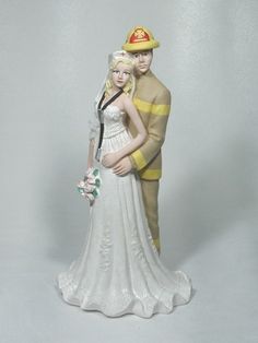 a wedding cake topper with a fireman and bride