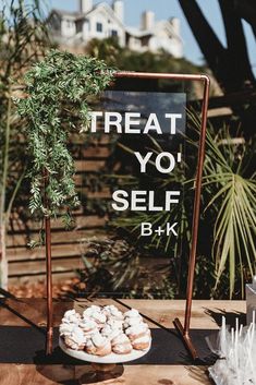 a sign that says treat yo'self and some pastries on a plate next to it