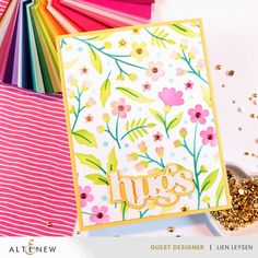 a card with flowers and the word hugs on it, surrounded by other cards that include gold glitters