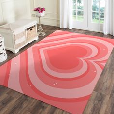 a pink rug with an abstract design on the floor in front of a white bench