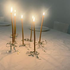 four candles are lit in the middle of a table