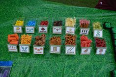 a table topped with lots of different types of snacks on top of green plastic bags