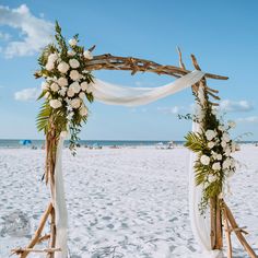 a wooden arch decorated with flowers and greenery on a beach Driftwood Wedding Arches, Beach Wedding Arbors, Bamboo Arch, Driftwood Wedding, Decorative Branches, Beach Wedding Arch, Beach Wedding Decorations Reception, Wedding Arbors, Florida Destinations